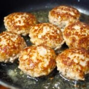 seven sausage patties in a pan