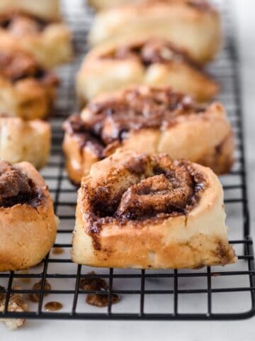 whole wheat cinnamon rolls in rows on a cooling rack