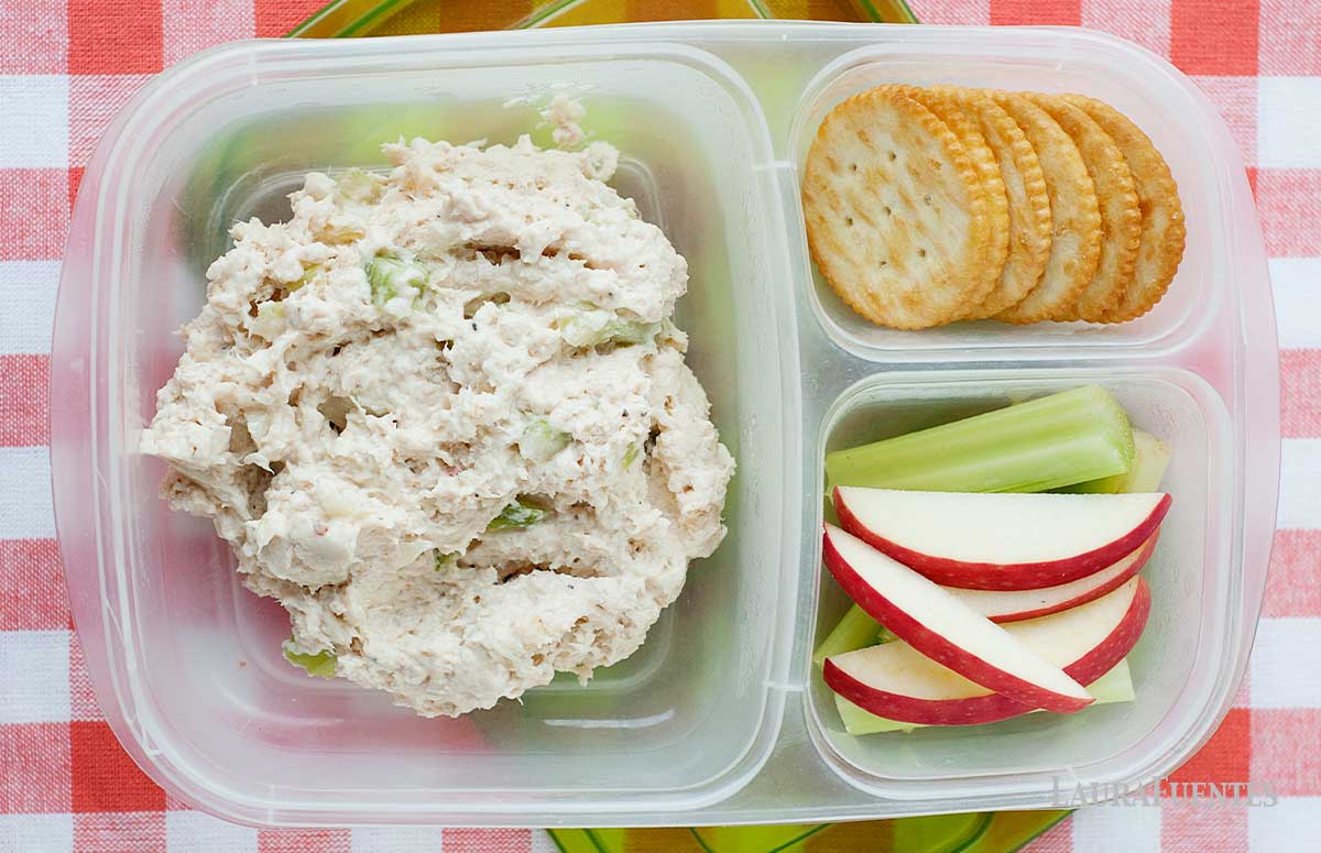 healthy southern chicken salad in a lunchbox with crackers, celery, and sliced apples.