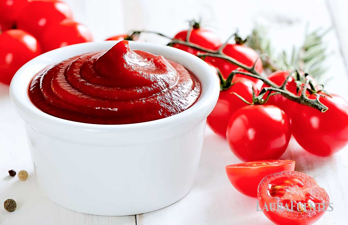 small dish of homemade ketchup with tomatoes around it