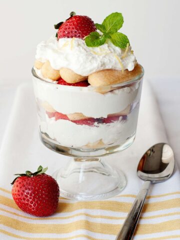 Strawberry Trifle With Lady Fingers next to a spoon and a strawberry