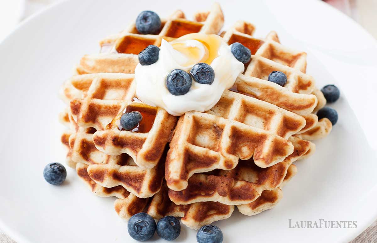 stack of two waffles topped with whipped cream and blueberries