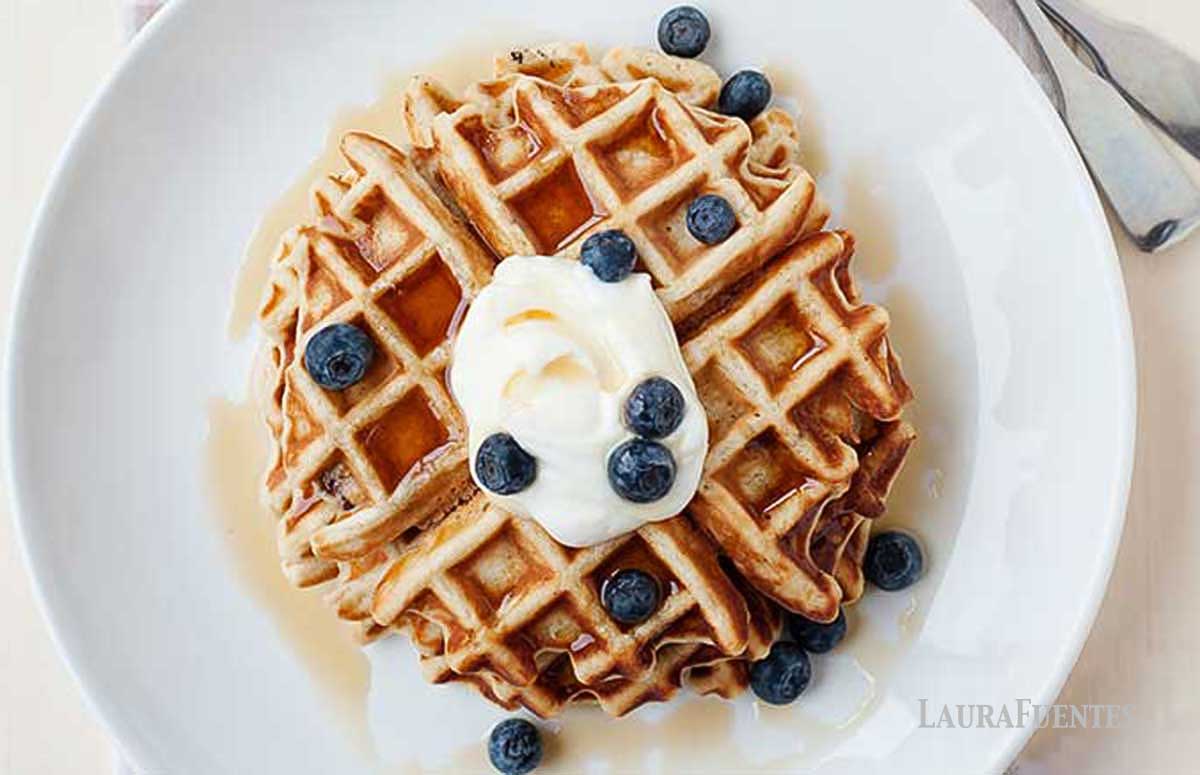overhead view of waffles topped with whipped cream and blueberries