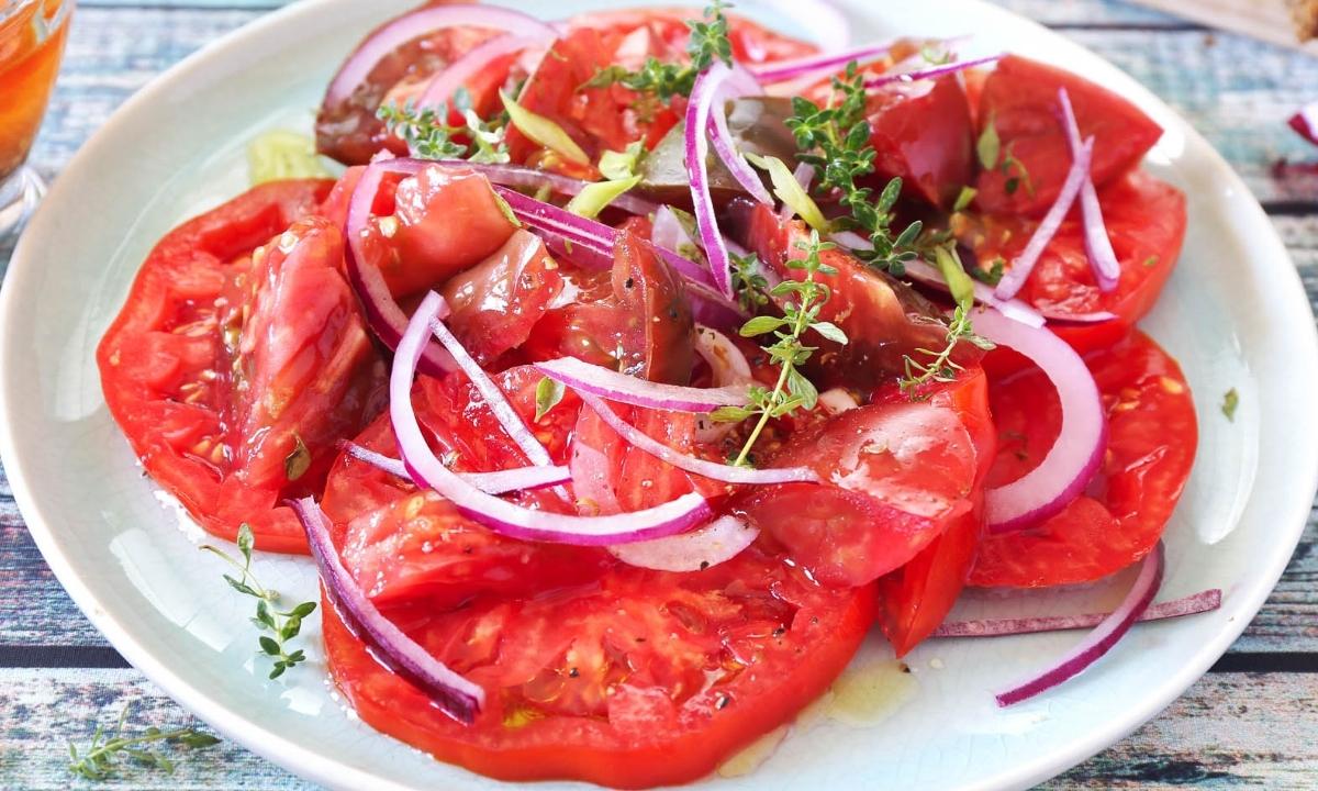 creole tomato salad with onion in a white dish