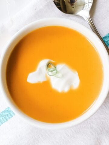 large bowl of orange colored spiced butternut squash soup