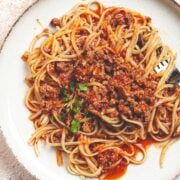 overhead view of homemade spaghetti bolognese on a plate with a fork