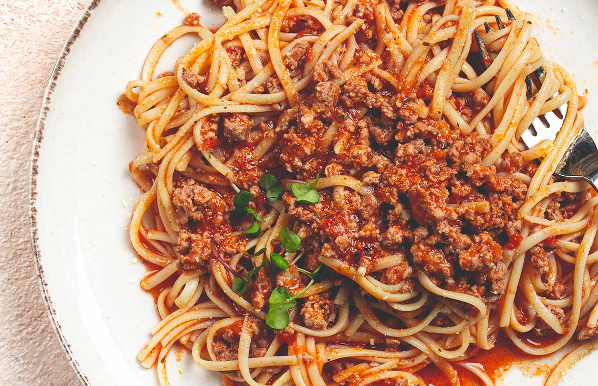 overhead view of homemade spaghetti bolognese on a plate with a fork