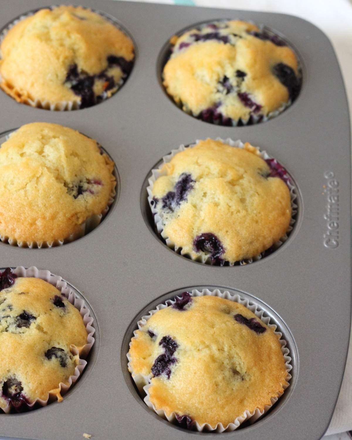 six blueberry muffins in a muffin tin