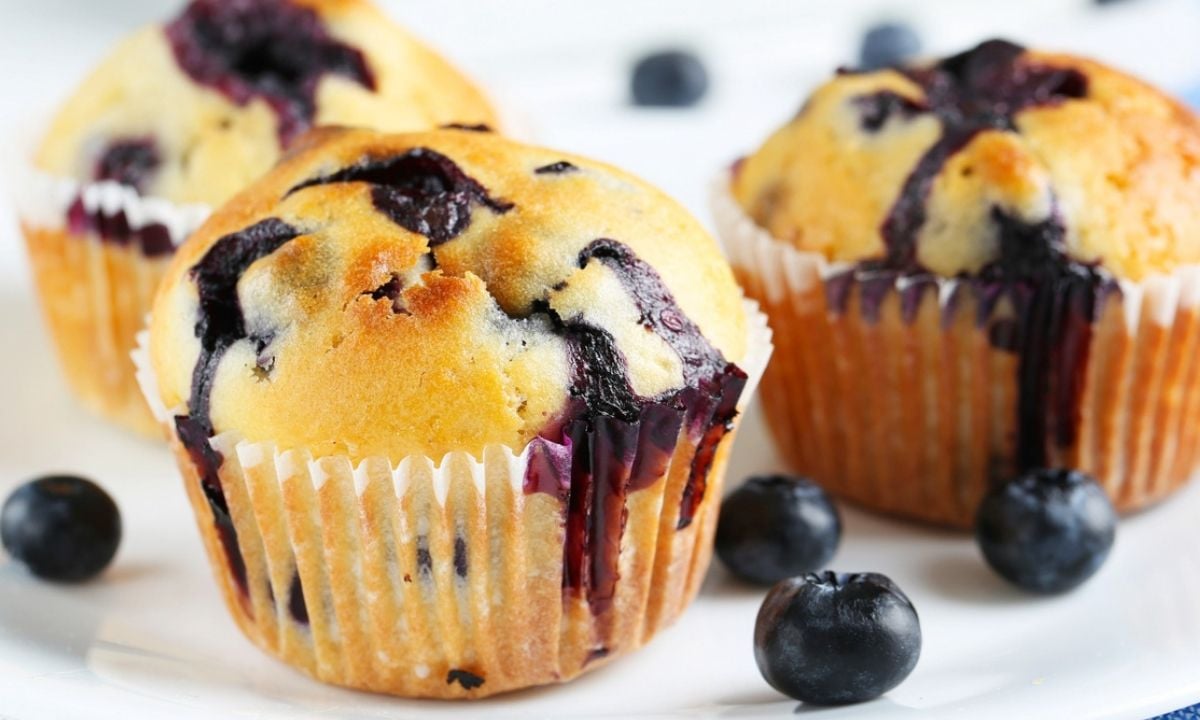 soft and golden blueberry muffins on a plate made with frozen blueberries