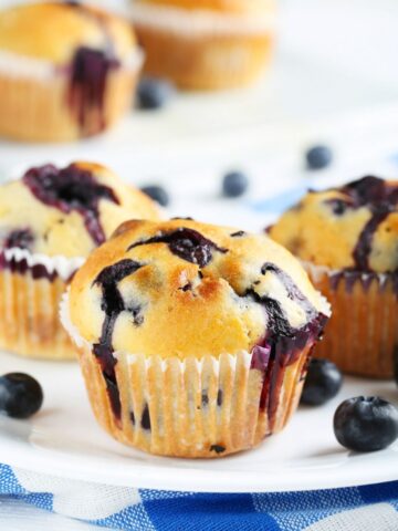 soft and golden blueberry muffins on a plate made with frozen blueberries