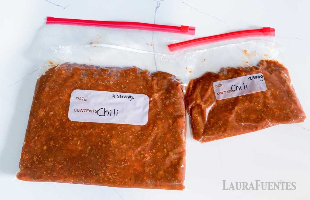 two bags of frozen chili side by side on a countertop