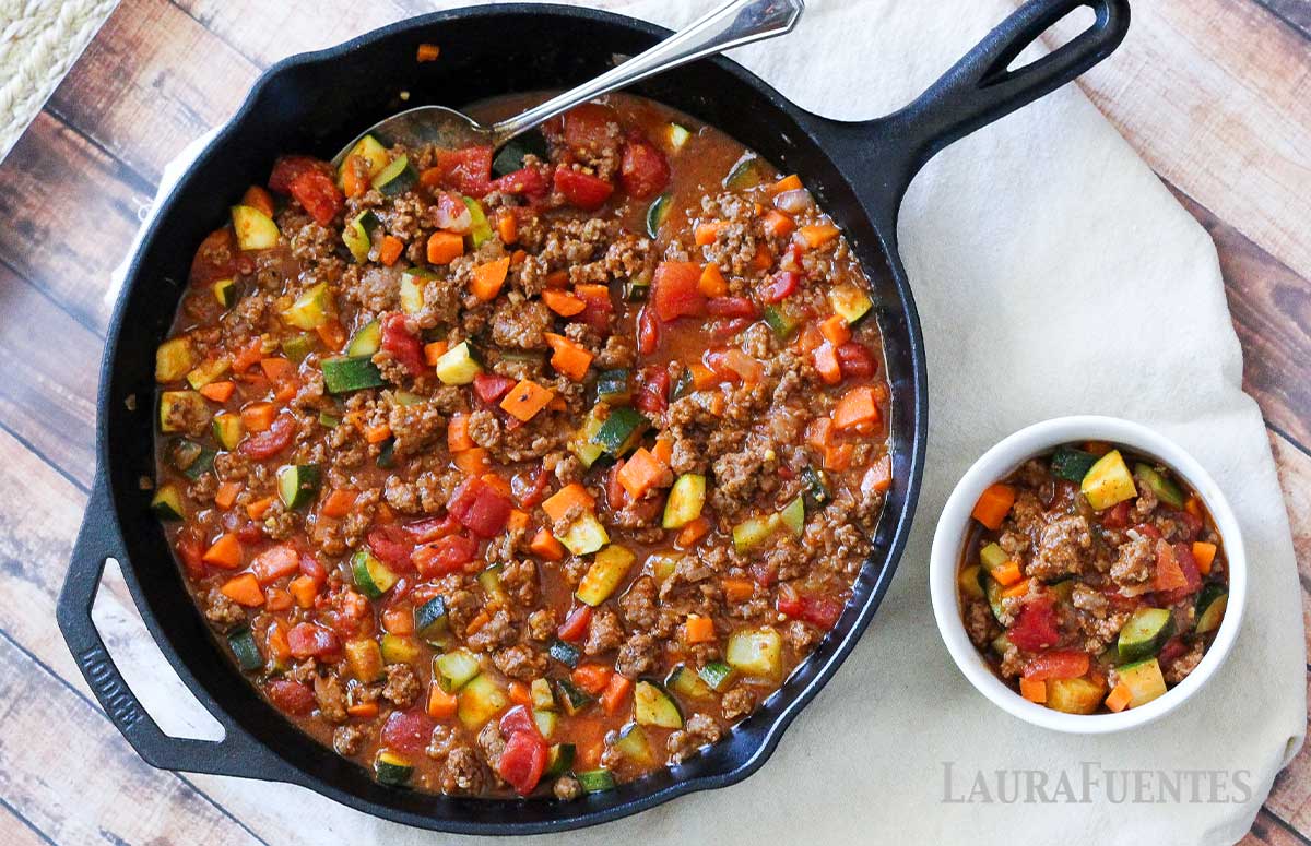 Skillet of paleo chili with a small bowl of chili to one side