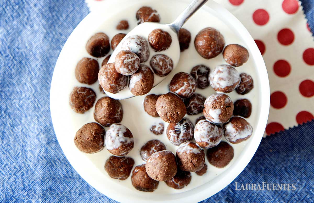 cocoa puffs in a bowl with milk and a spoon in it