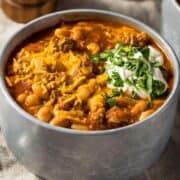 overhead view of a bowl filled with turkey pumpkin chili topped with a little sour cream and chives