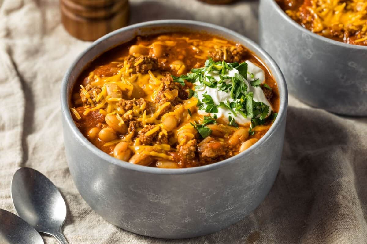 overhead view of a bowl filled with turkey pumpkin chili topped with a little sour cream and chives