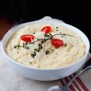 large bowl of parmesan polenta topped with tomatoes