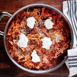 overhead image of skillet lasagna recipe made with pasta, cheese, and tomato sauce and sausage
