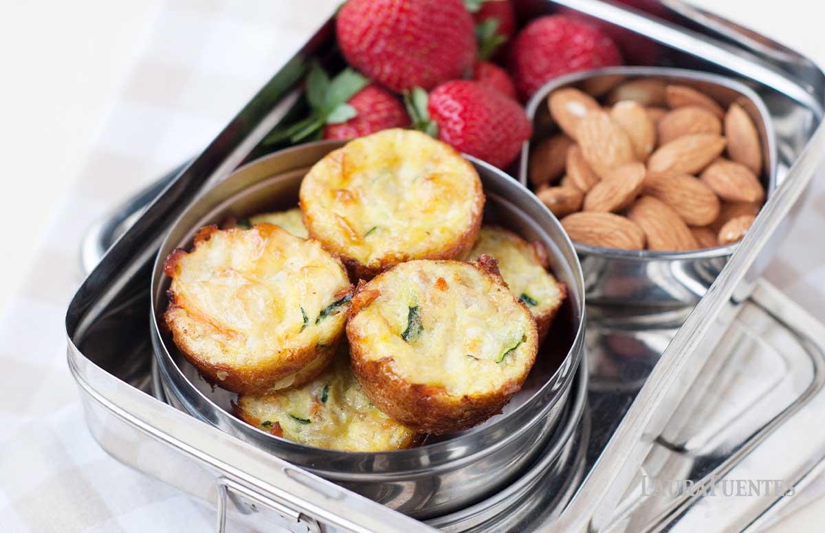 silver lunchbox with bowl of almonds, strawberries and small mini quiches