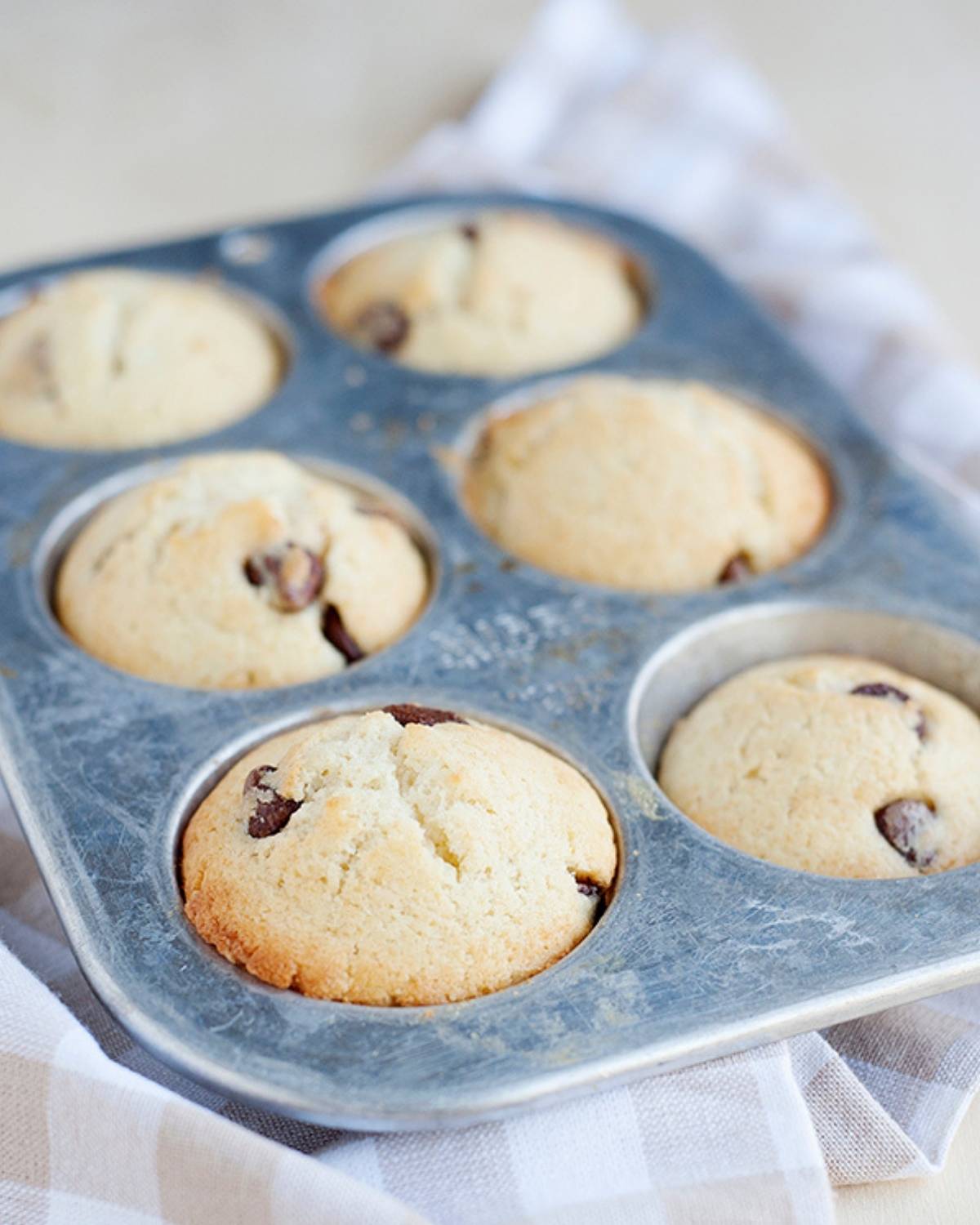 a muffin tin with six chocolate chip pancake muffins