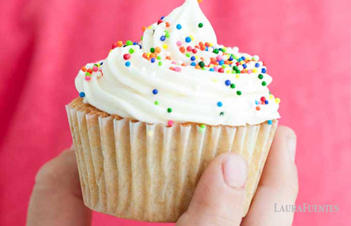 a person holding a birthday cupcake