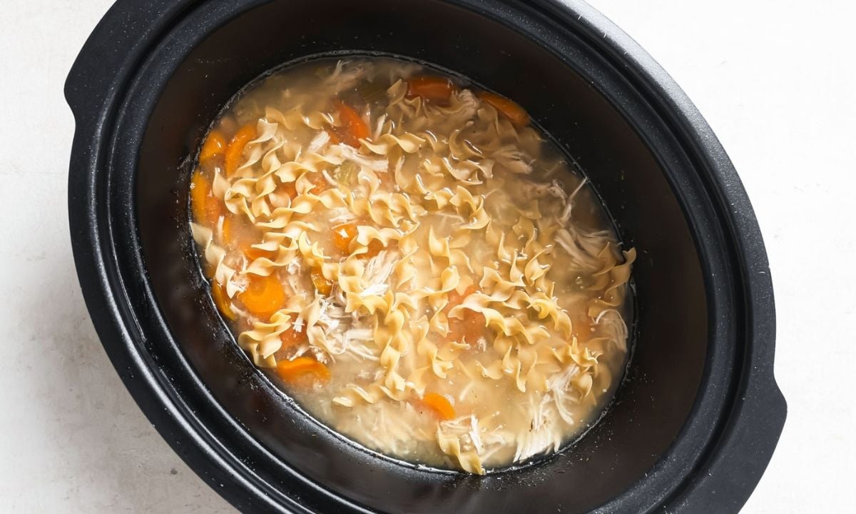 cooked chicken noodle soup with carrrots in the slow cooker