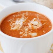 creamy tomato tortelliny soup in a white cup