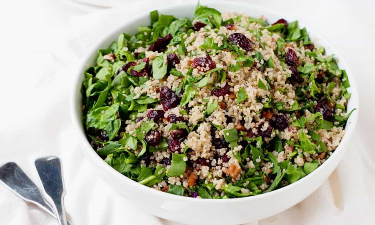 a bowl quinoa salad with cranberries and greens