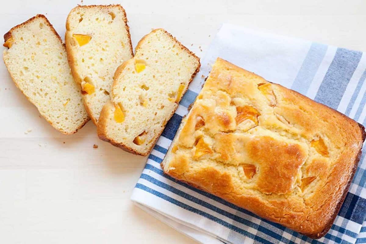 loaf of peach bread with three slices cut