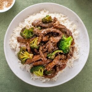 overhead view of beef broccoli over rice on a plate.