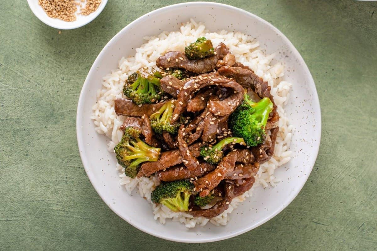 overhead view of beef broccoli over rice on a plate.