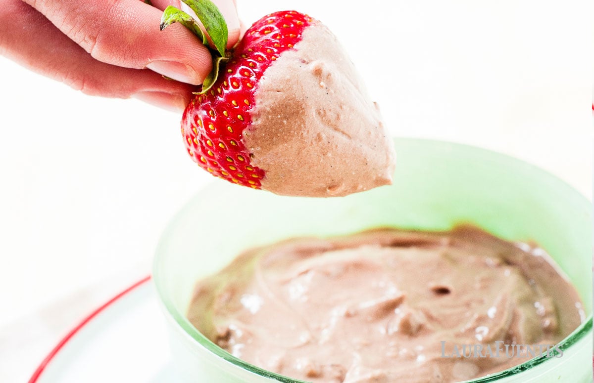 Chocolate Peanut Butter Yogurt Dip on a plate with a strawberry dipped in it