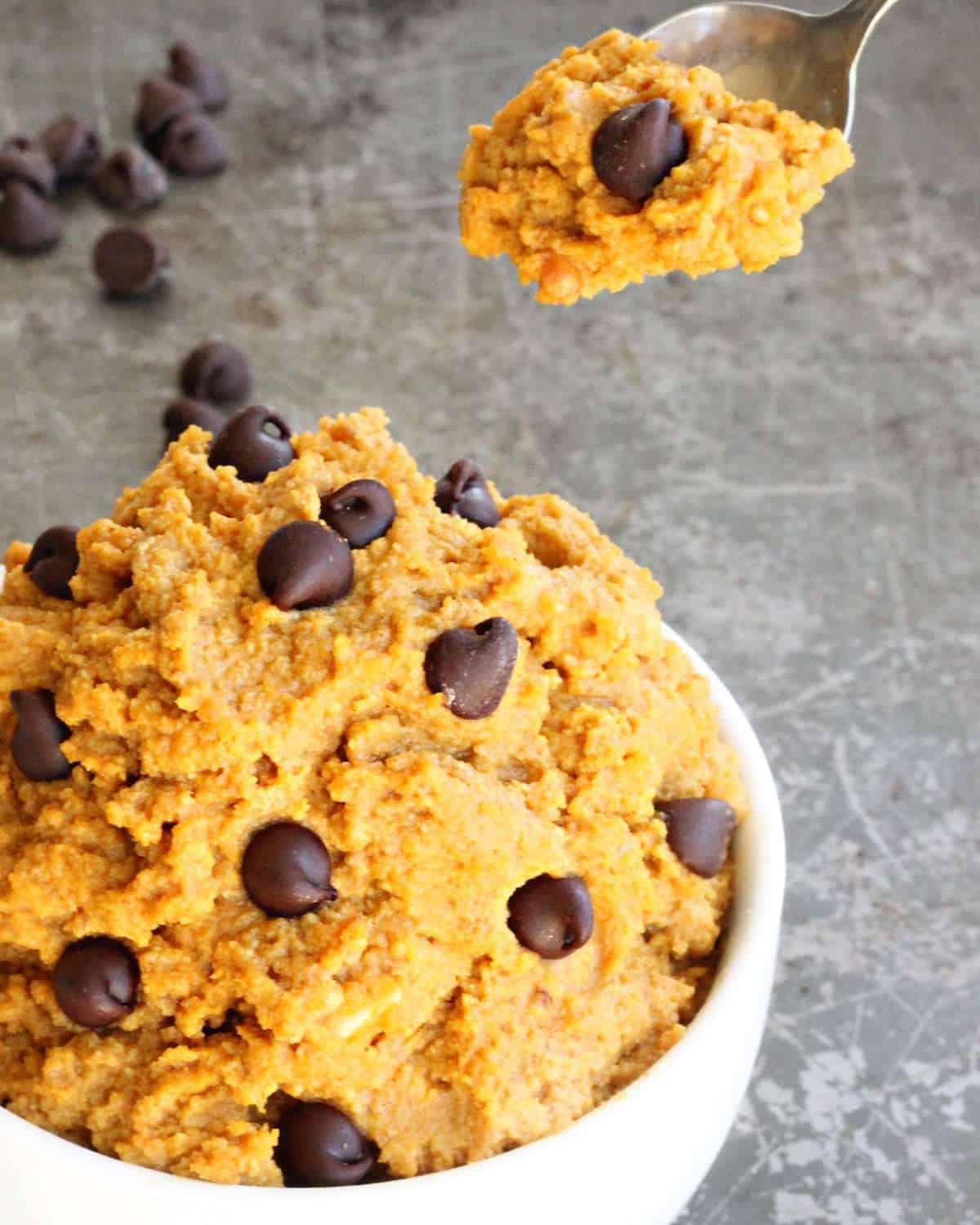 Pumpkin Spice Cookie Dough Dip in a white bowl with a spoon of cookie dough