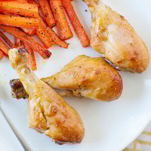 overhead view of honey chicken legs on a plate with carrot fries