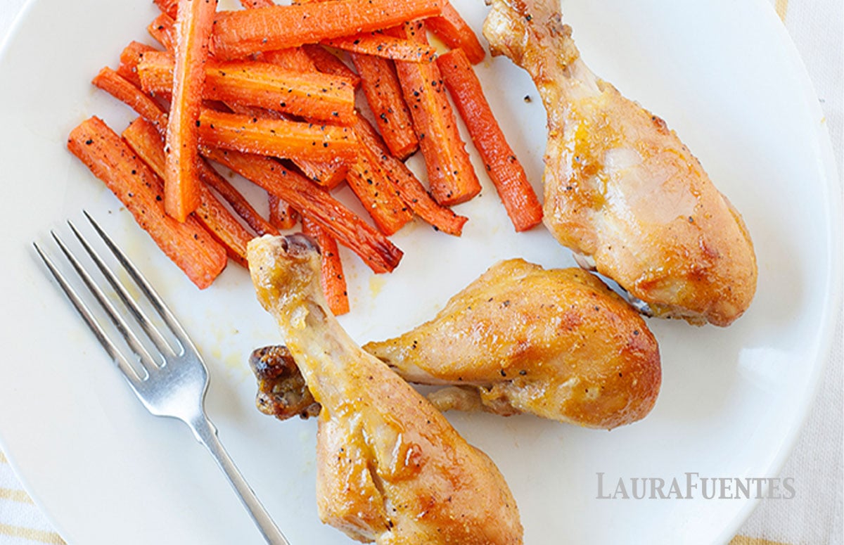 overhead view of honey chicken legs on a plate with carrot fries