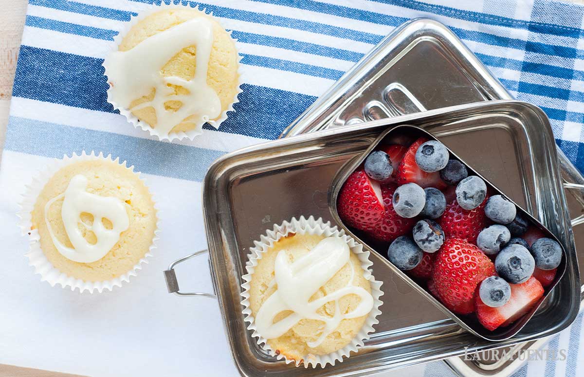 three lemon yogurt muffins and berries in a lunchbox