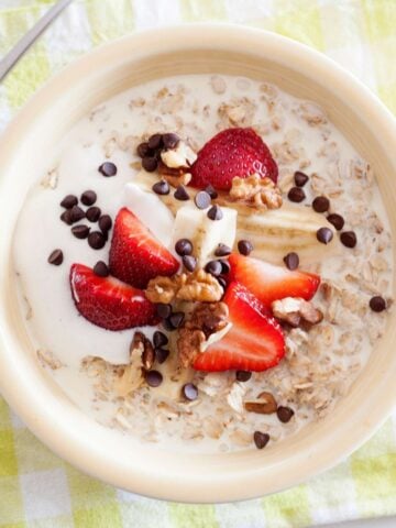 strawberry banana oatmeal topped with yogurt, nuts and chocolate chips