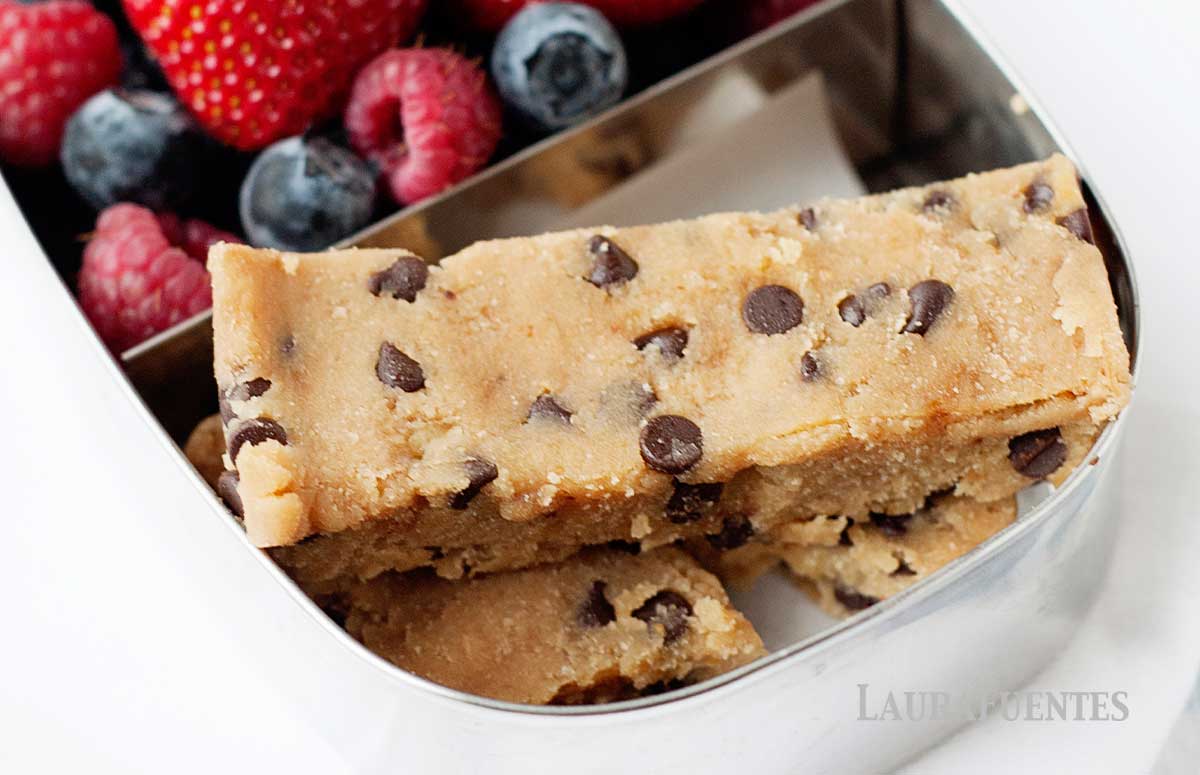 three no bake blondies in a small snack box with berries
