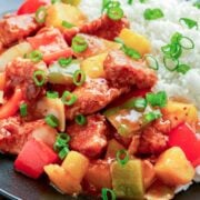 close up of pineapple pork stir fry and rice on the side
