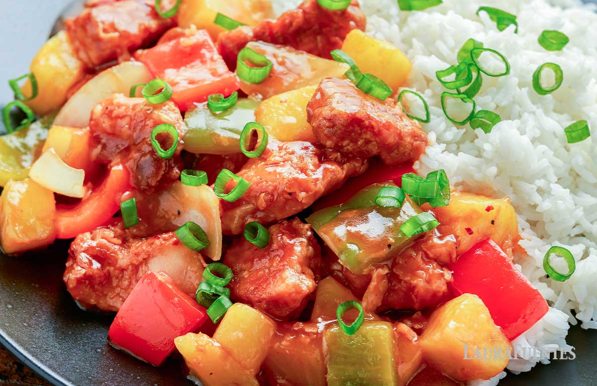 close up of pineapple pork stir fry and rice on the side