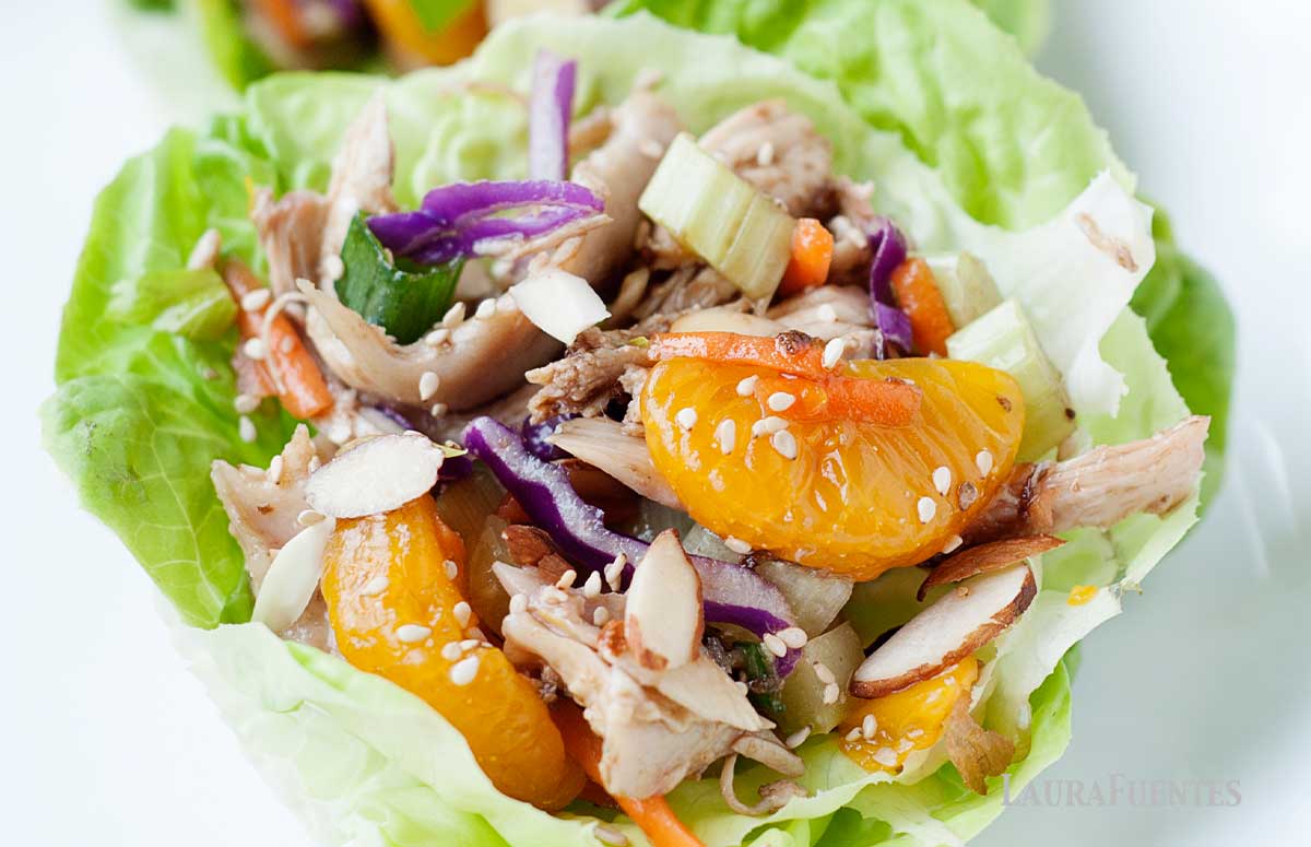 image: closeup of white plate with chopsticks, and a lettuce cup filled with asian chicken salad