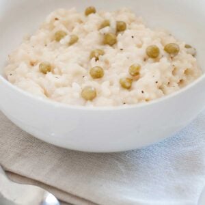 closeup of a big bowl of risotto with parmesan and peas