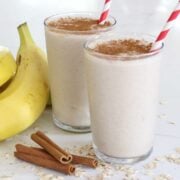 two glasses of cinnamon roll smoothies with cinnamon on top