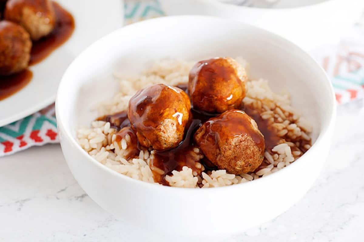 bowl of sweet and sour meatballs served over rice