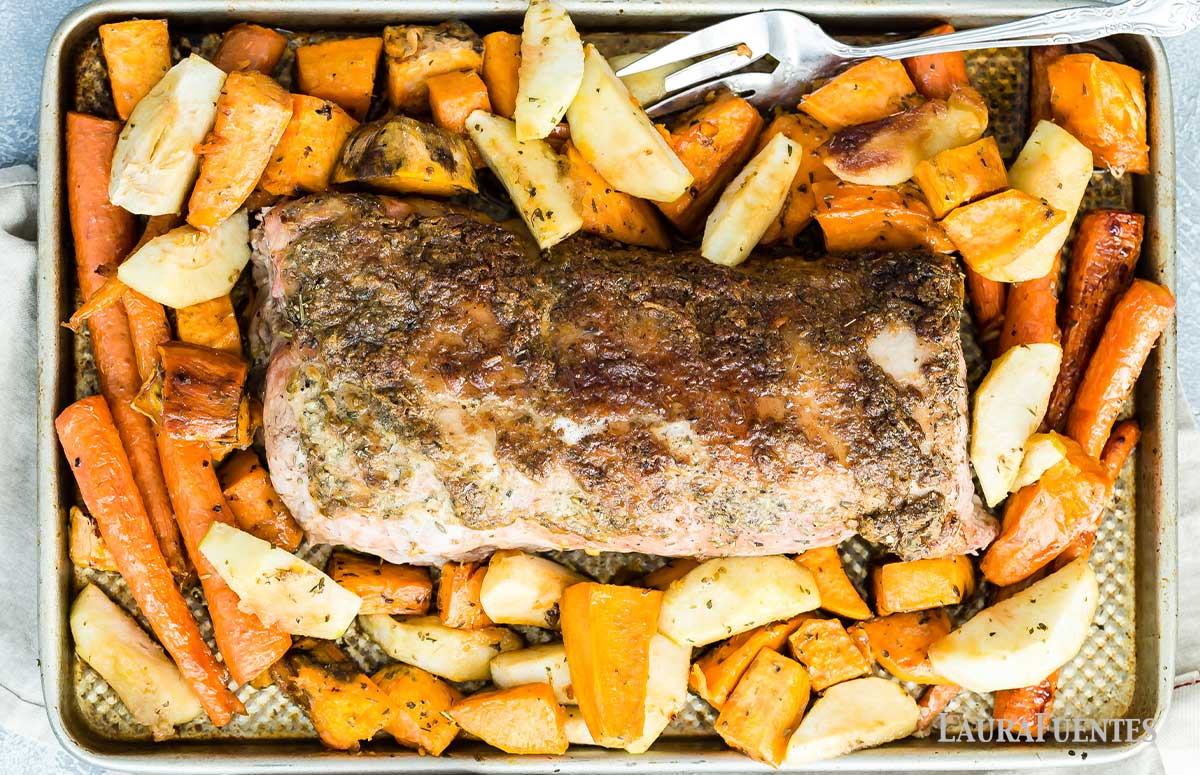 overhead view of easy sheet pan pork roast with a brown sugar and dijon glaze with sweet potatoes and carrots on a baking tray