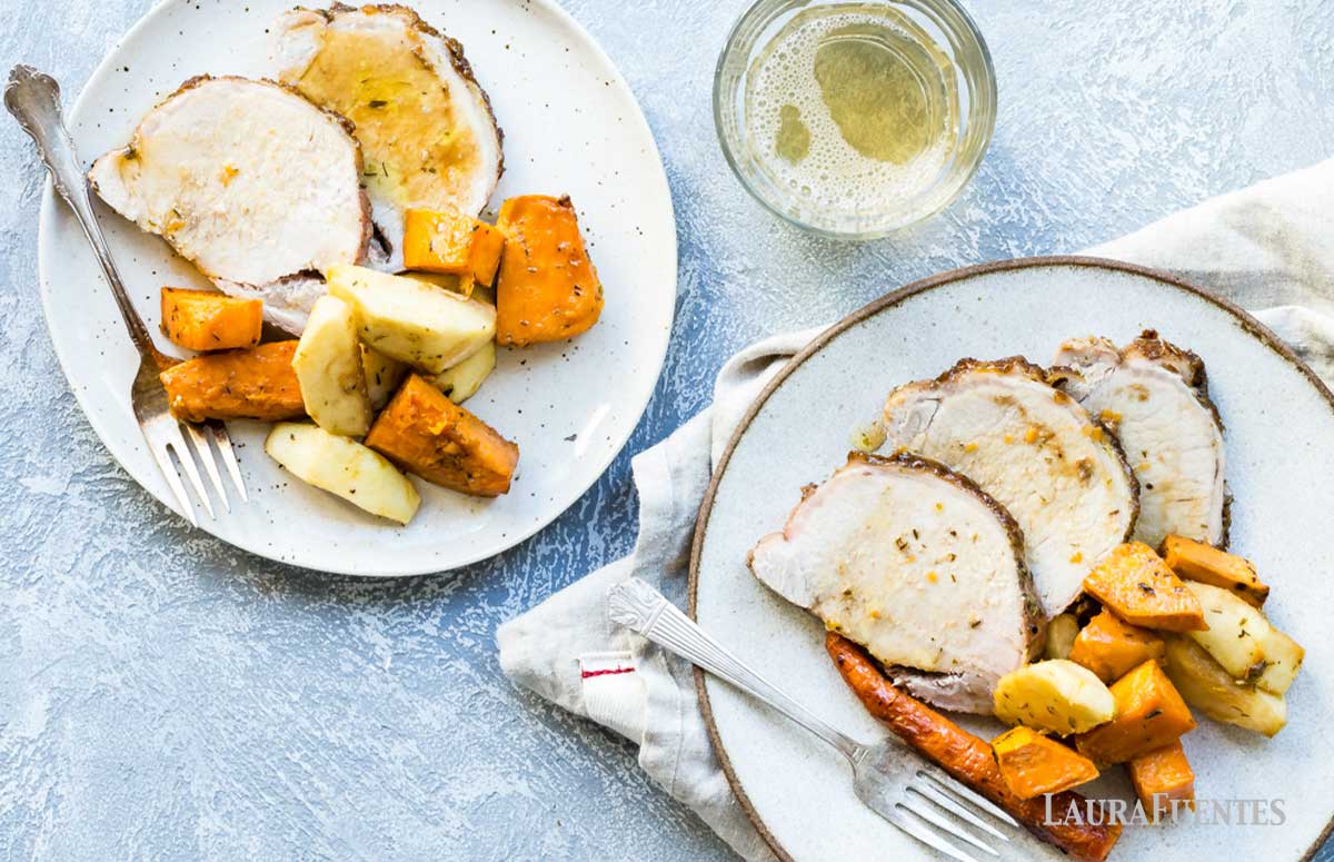 overhead view of two plates of sheet pan pork roast with a brown sugar and dijon glaze with sweet potatoes and carrots