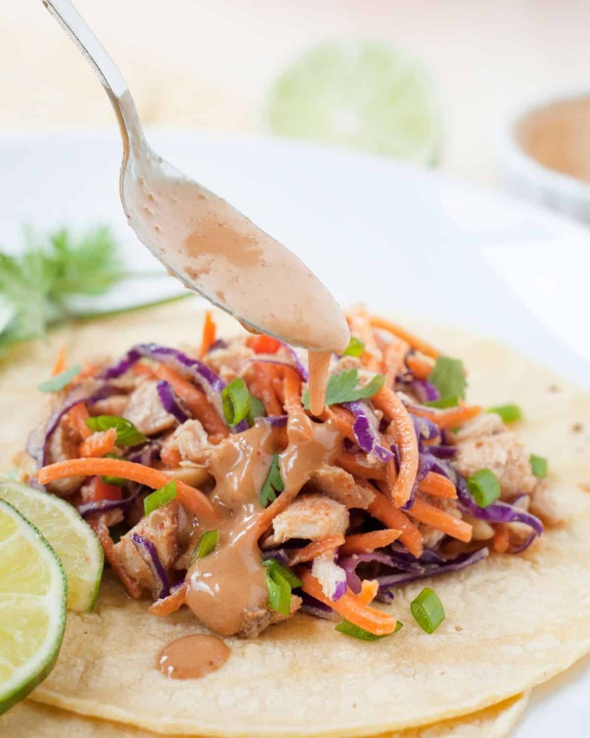thai chicken taco with being drizzled with peanut sauce