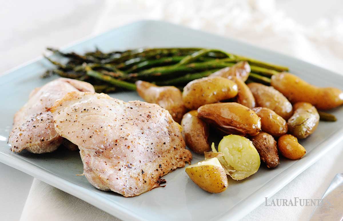 baked chicken, asparagus and potatoes arranged on a square blue plate for dinner