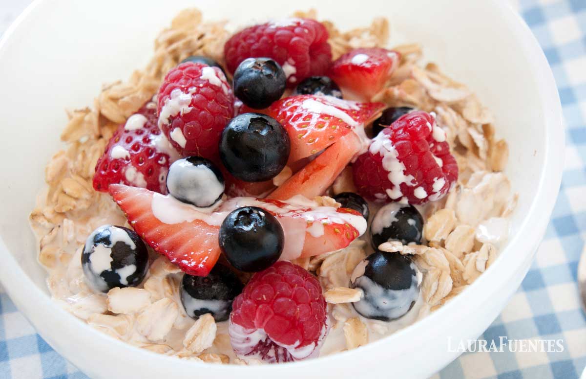 cold oatmeal with berries in a white bowl