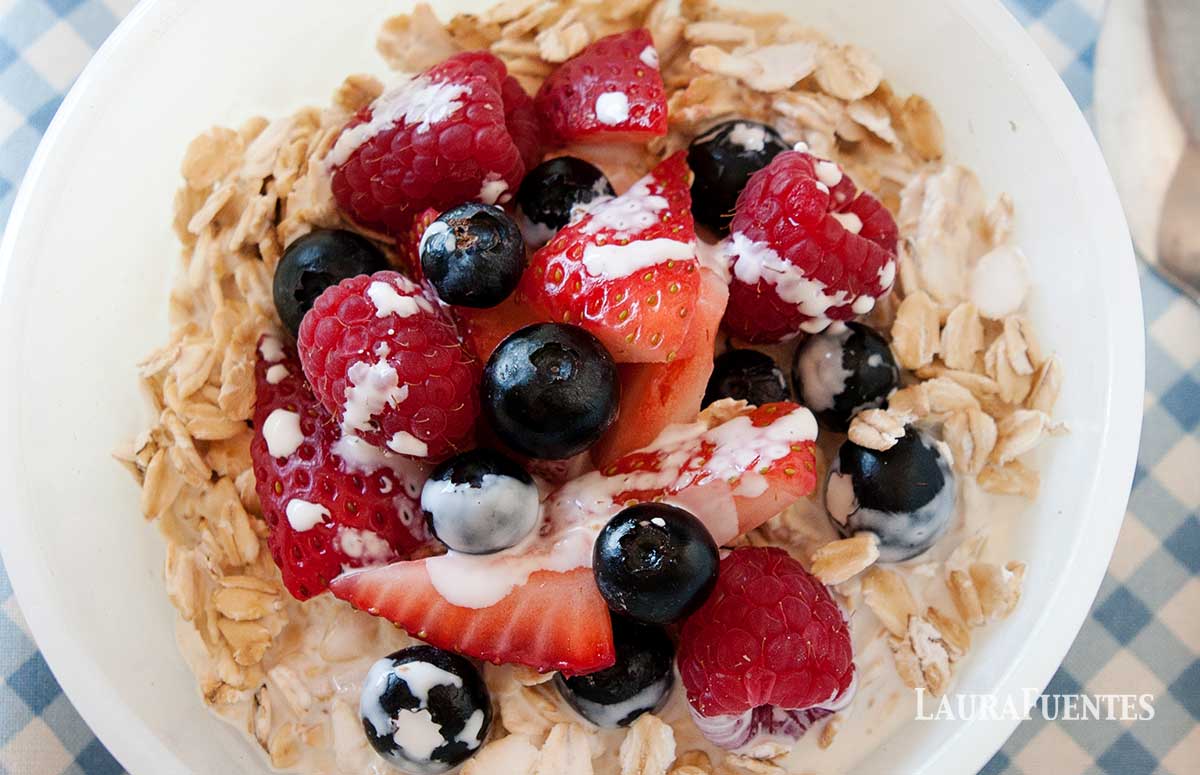cold oatmeal with berries in a white bowl