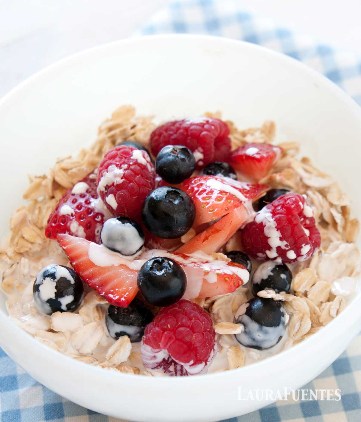 cold oatmeal with berries in a white bowl